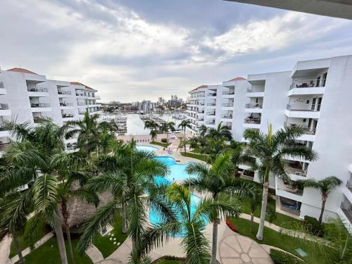 an aerial view of a resort with a pool and palm trees at Hermoso en marina, asombrosas vistas by G P S rentas in Mazatlán