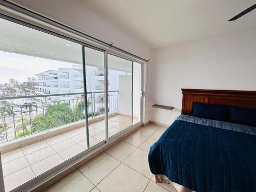 a bedroom with a bed and a large window at Hermoso en marina, asombrosas vistas by G P S rentas in Mazatlán