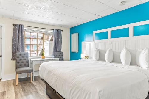 een slaapkamer met een groot wit bed en een bureau bij Royal Crest Inn - Hampton Beach in Hampton