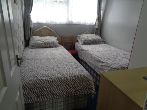 2 camas en una habitación pequeña con ventana en 204 BELLE AIRE, en Hemsby
