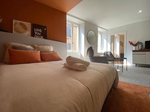 a bedroom with a large white bed with orange walls at LE CARNOT - Valence in Bourg-lès-Valence