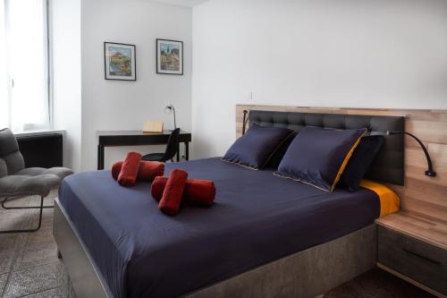 une chambre avec un grand lit avec des oreillers rouges dans l'établissement Le Pécharmant - lescapade medievale Sarlat, à Sarlat-la-Canéda