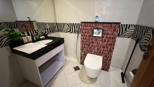 a small bathroom with a toilet and a sink at Centaurus Apartment City View Three Beds in Islamabad