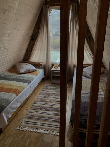 two beds in a room with a window at VIP-Domyk in Rakhiv