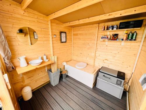 Una vista interior de una pequeña cabaña de madera con estufa. en Romantik pur - Schlafen unter dem Sternenhimmel, en Wadersloh