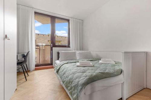 a white bedroom with a bed and a large window at Elegant City Escape - Modern & Central in Bratislava