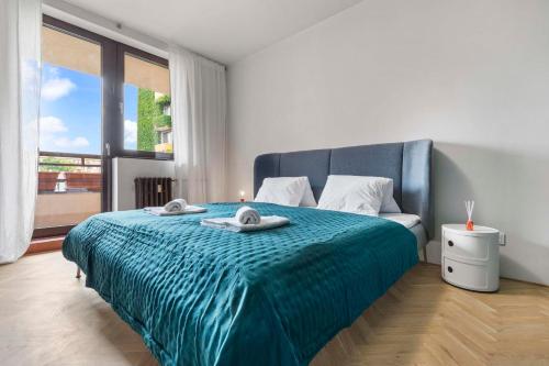 a bedroom with a blue bed with towels on it at Elegant City Escape - Modern & Central in Bratislava