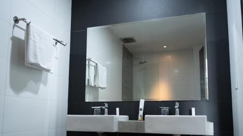 a bathroom with two sinks and a large mirror at Beverly Hotel in Taiping