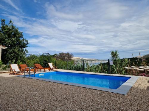 a swimming pool with two lounge chairs next to it at Villa Panama in Pag