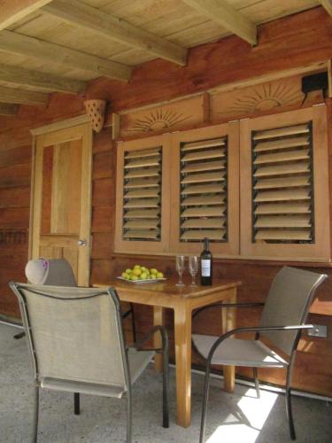 a dining room with a table with chairs and a bottle of wine at Castara Retreats in Castara
