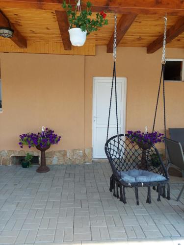 a porch with a swing with flowers on it at Casa Cristina in Cîrţişoara
