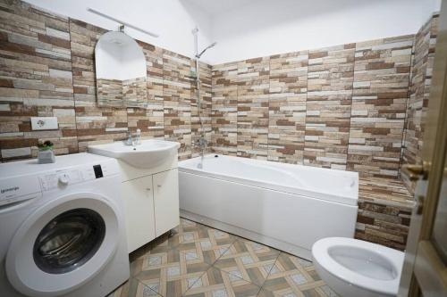 a bathroom with a washing machine and a toilet at Alex 2 Apartament in Iaşi