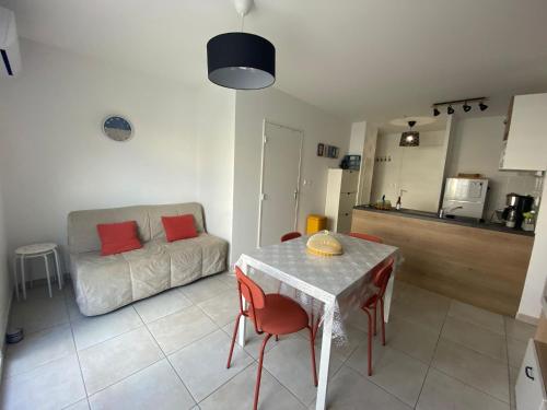 un salon avec une table et un canapé dans l'établissement Le rêve au soleil les pieds dans l'eau - Villa 6 personnes en résidence avec piscine à 700 m des plages, à Sérignan