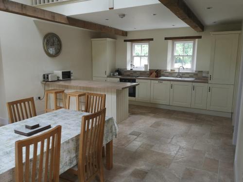 a kitchen with a table and chairs and a sink at Lovely 3-Bed House at Clashganny Mill Borris in Carlow