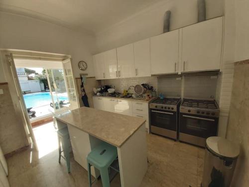 a kitchen with white cabinets and a counter top at Lisbon Blue House in Oeiras