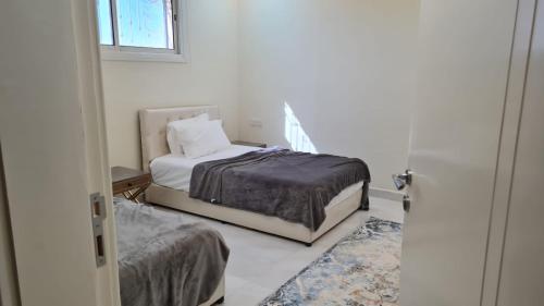 a small bedroom with a bed and a window at فيلا المشراق دورين 4غرف نوم وصالة وصالة معيشة مع شالية ومسبح داخلي in Buraydah