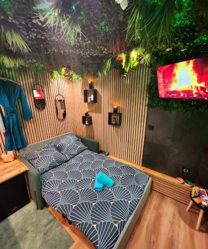 ein Schlafzimmer mit einem Bett in einem Zimmer in der Unterkunft Jungle House avec Jacuzzi à 10 min de Disneyland -Taille Chambre- in Condé-Sainte-Libiaire