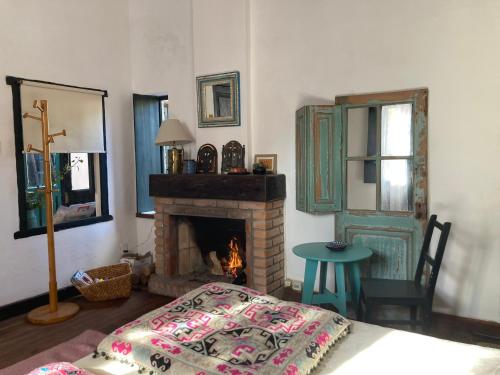 Habitación con chimenea, cama y mesa. en Rincón Colonial en Colonia del Sacramento