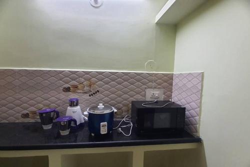 a counter with a coffee maker and a microwave at Newly renovated & furnished 2-Bedroom MVP colony in Visakhapatnam