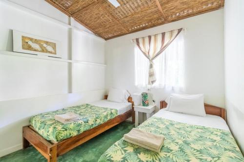 a bedroom with two beds and a window at Bajo el Arbol B&B in Santa Teresa Beach