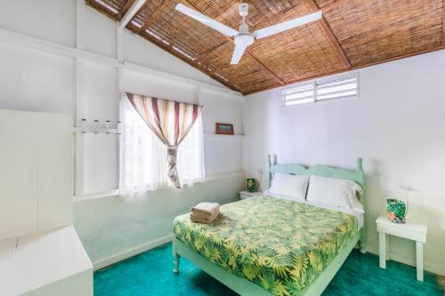 a bedroom with a bed and a ceiling fan at Bajo el Arbol B&B in Santa Teresa Beach