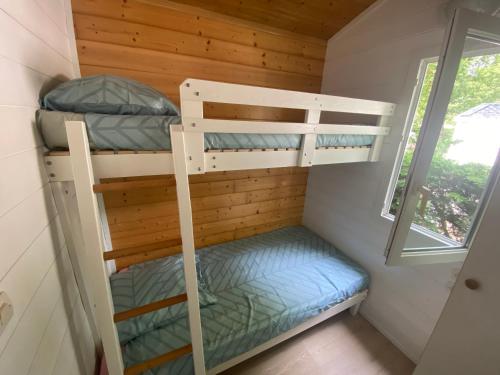 a bedroom with bunk beds in a tiny house at Le chalet Arcachonais in La Teste-de-Buch