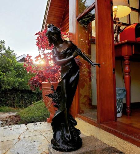 a statue of a woman holding a baseball bat at Mansão Austríaca Guesthouse in Campos do Jordão