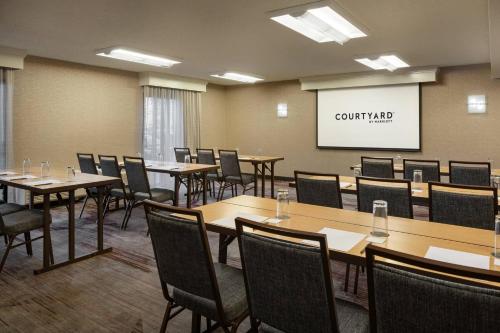 a conference room with tables and chairs and a whiteboard at Courtyard by Marriott San Francisco Airport in San Bruno