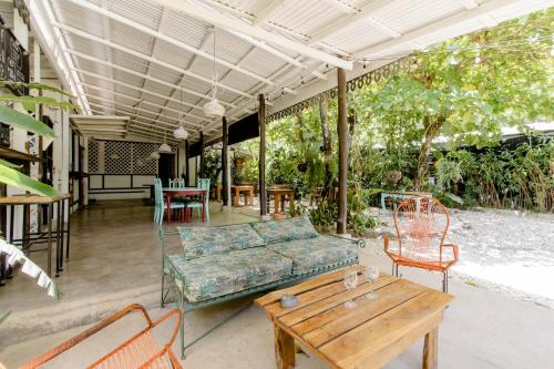 a patio with a couch and a table and chairs at Bajo el Arbol B&B in Santa Teresa Beach