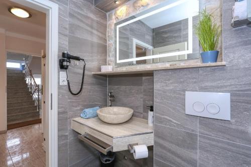 y baño con lavabo y espejo. en Zaton beach Appartement 4 modern und stilvoll mit Balkon in Strandnähe, en Zaton