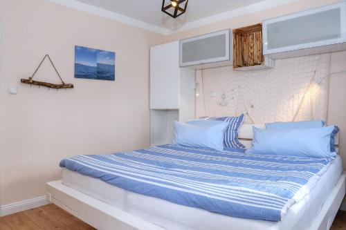 1 dormitorio con 1 cama con almohadas azules y blancas en Zaton beach Appartement 4 modern und stilvoll mit Balkon in Strandnähe, en Zaton