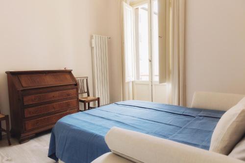 um quarto com uma cama azul e uma cómoda em Firenze House Zanella em Florença