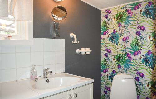 a bathroom with a sink and a flower shower curtain at Pet Friendly Home In Backaryd With House A Panoramic View in Backaryd
