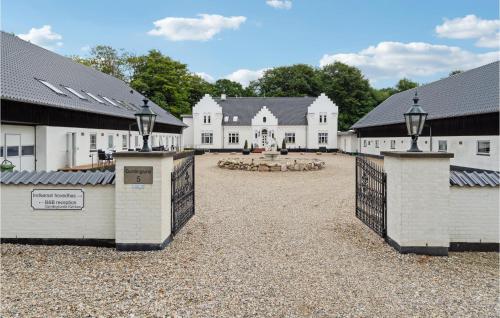 a large white house with a gate in front of it at 11 Bedroom Cozy Home In Gørding in Gørding