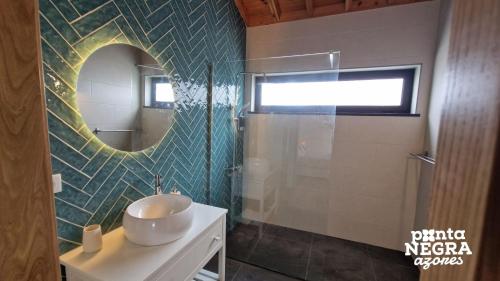 ein Bad mit einem Waschbecken und einem Spiegel in der Unterkunft Photography House in Altares
