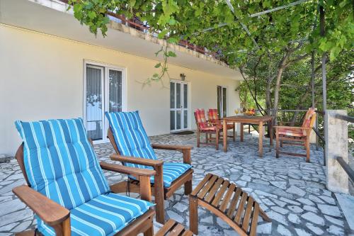 a group of chairs and tables on a patio at Bojana Apartments in Cavtat