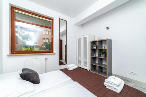 a bedroom with a white bed and a window at Safari - Neptun Park by OneApartments in Gdańsk