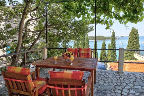 a table and chairs on a patio with a view of the water at Bojana Apartments in Cavtat