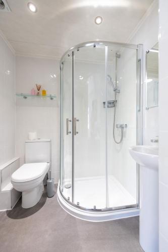 a bathroom with a shower and a toilet and a sink at The Woodlands Hotel in Sidmouth