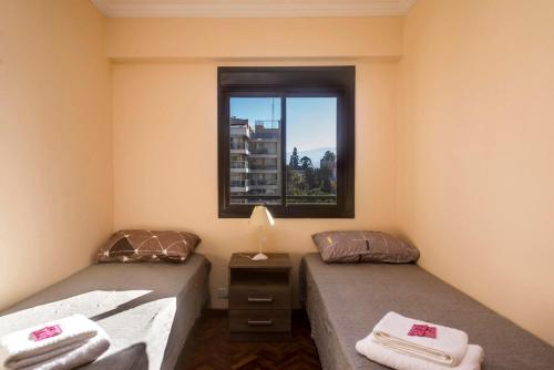two twin beds in a room with a window at Departamento céntrico en la Ciudad de Salta, a 5 cuadras de la plaza principal in Salta