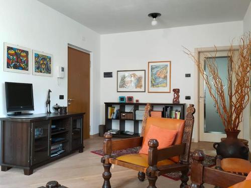 uma sala de estar com uma televisão e uma cadeira em Appartamento al Parco, Brentonico em Brentonico