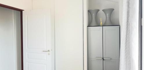 a white cabinet with two vases on top of it at VILLA 6 à 8 personnes dans résidence de tourisme in Argelès-sur-Mer