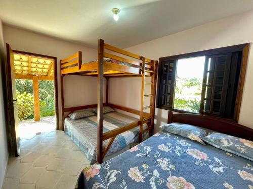 two bunk beds in a room with a window at Chácara Mira Flores in Atibaia
