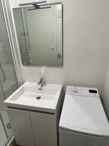 a white bathroom with a sink and a mirror at Vivez le Bonheur - Plage - Port de plaisance - Vue mer in Le Havre