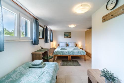 1 dormitorio con 2 camas y mesa en Villa Maria Škrip en Škrip