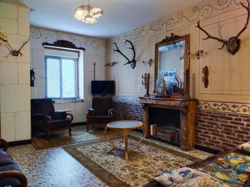 un salon avec une cheminée et un miroir dans l'établissement Le jardin Renard-Clos sur Loir cottage in the Loir & Loire valleys, à La Chapelle-aux-Choux