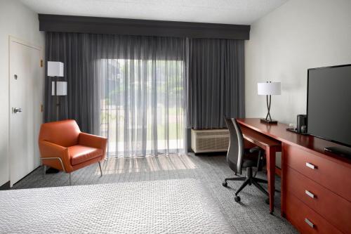 a hotel room with a desk and a chair and a television at Courtyard Philadelphia Valley Forge / King of Prussia in Wayne