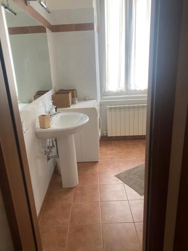a bathroom with a white sink and a tile floor at Al piccolo castelliere in Trieste
