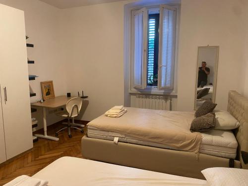 a room with two beds and a desk and a mirror at Al piccolo castelliere in Trieste