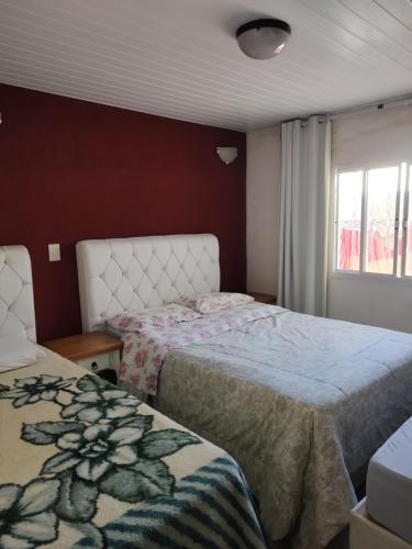 um quarto com 2 camas e uma janela em Casa Térrea Oliveira inteira em São José dos Pinhais